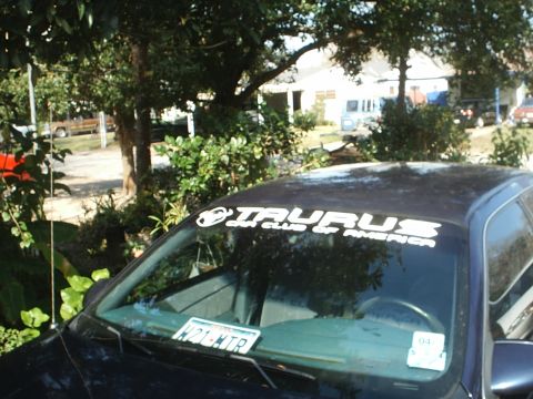 1993 Ford Taurus - A dark blue 1993 Ford Taurus is parked outdoors, with a club sticker visible on its windshield.