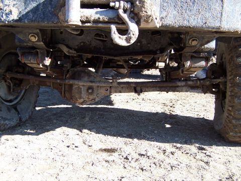 1979 Ford Bronco - Close-up of the undercarriage, showing the suspension and winch mechanism of a off-road vehicle.