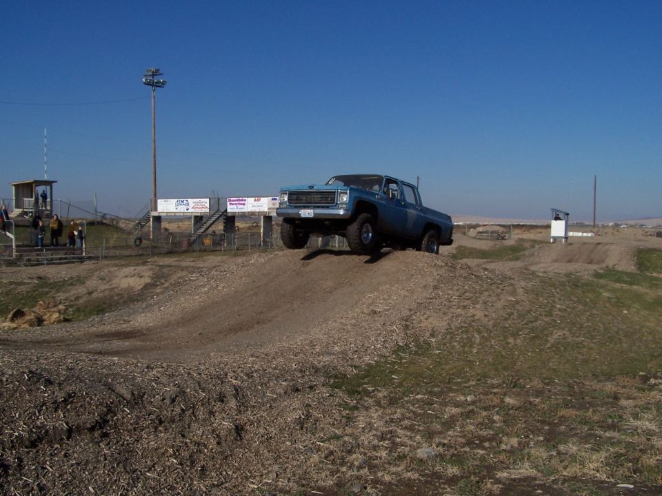 Blue 1973 GMC pickup truck on dirt ramp