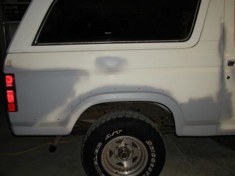 1986 Ford Bronco - This white SUV's rear quarter panel shows signs of recent bodywork and repair.
