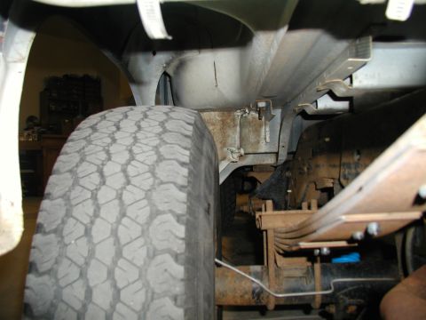 1986 Ford Bronco - Undercarriage view of a 1986 Ford Bronco, focusing on the tire and suspension components.