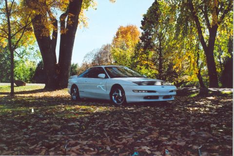 1996 Ford Probe - 1996 Ford Probe parked outdoors during autumn with colorful leaves on the ground and trees.
