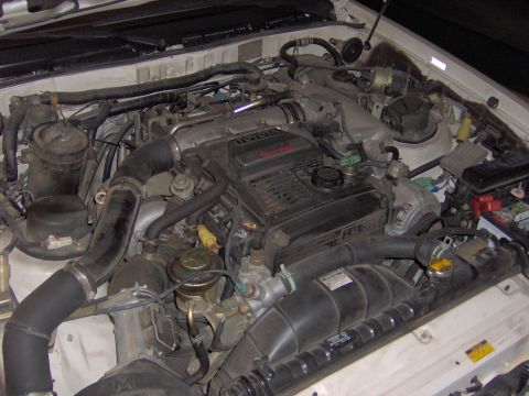 1994 Ford Probe - Engine bay of a white vehicle, showing a Toyota engine and associated components.