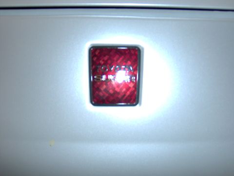 1994 Ford Probe - Close-up of a red reflector badge on a vehicle's exterior panel.