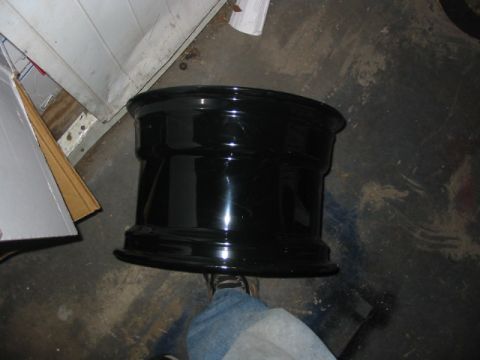 1985 Ford LTD Crown Victoria - A black car wheel is shown in a garage setting.