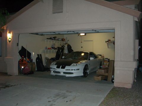 1996 Ford Probe - A white 1996 Ford Probe with black hood stripes is parked inside a garage.