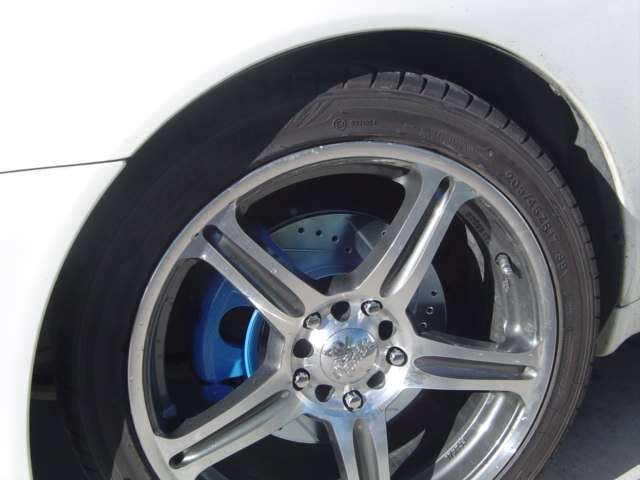 Polished 5-spoke wheel with blue caliper and drilled rotor on white 1999 Honda Prelude