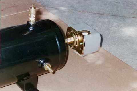 1994 Ford Bronco - Close-up of an air compressor tank fitting with a brass valve and grey housing.