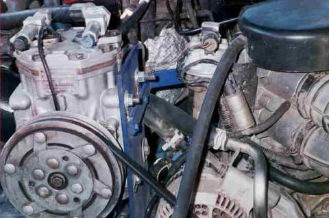 1994 Ford Bronco - A detailed view of various engine parts and hoses within a vehicle's engine bay.