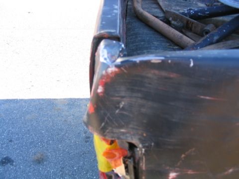 1986 Ford F-150 - Damaged corner of a truck bed shows rust and exposed material.