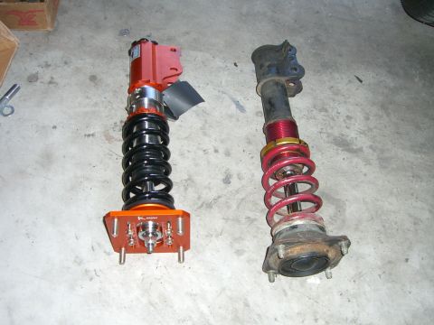 1996 Ford Probe - Comparison of two different vehicle suspension struts, one appears to be aftermarket.