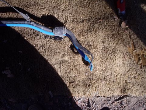 2000 Ford Taurus - A close-up view of a vehicle's suspension component, possibly a sway bar link, is shown against a carpeted surface.