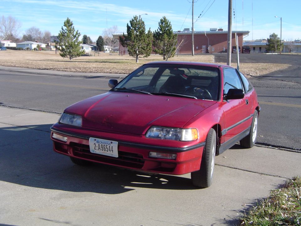 Red Honda CRX coupe parked on driveway, 3/4 front view with Montana plate