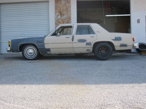 1985 Ford LTD Crown Victoria - This 1985 Ford Crown Victoria LTD shows primer-gray front fender and numerous body repair patches.