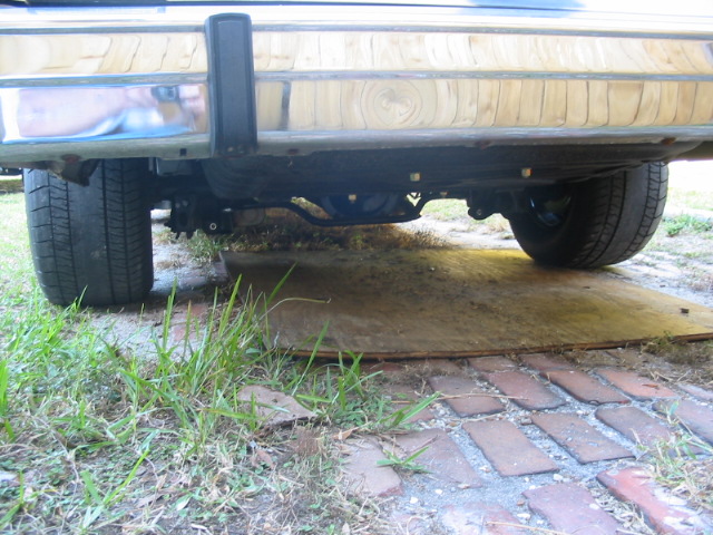 Underside view of a car's rear bumper, differential, and tires
