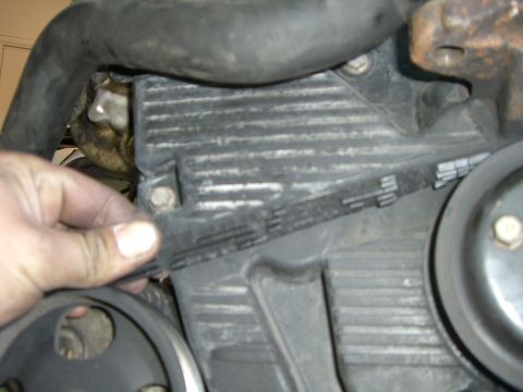 1996 Ford Probe - Close-up of a hand adjusting the timing belt on an engine component.