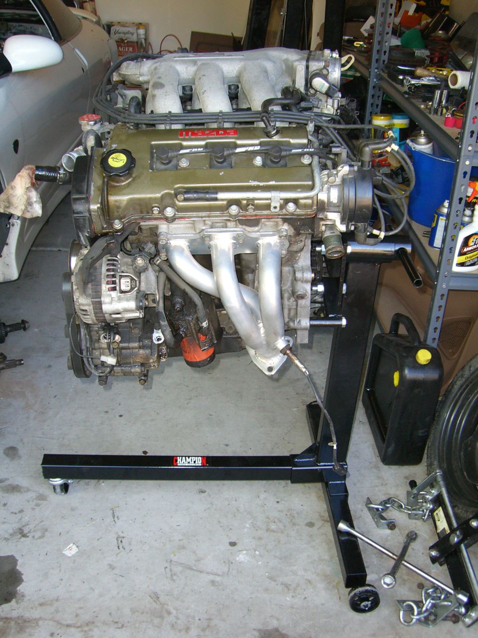 Mazda V6 engine on an engine stand, with tools and parts in the background
