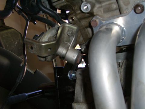 1996 Ford Probe - Close-up view of an engine component, focusing on a metal bracket and exhaust pipes.