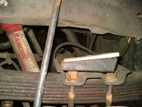 1989 Ford Bronco - Close-up view of vehicle's rear suspension components, including leaf springs and a shock absorber.