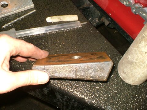 1989 Ford Bronco - Metal shim with a central hole is held by a hand, with tools in the background.