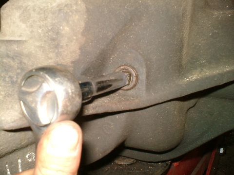 1989 Ford Bronco - Close-up of a socket wrench engaging a bolt on a vehicle's differential housing.