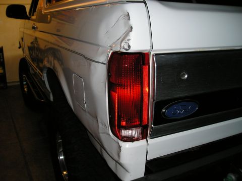 1993 Ford Bronco - Rear side view of a white Ford Bronco showing significant damage to the quarter panel.