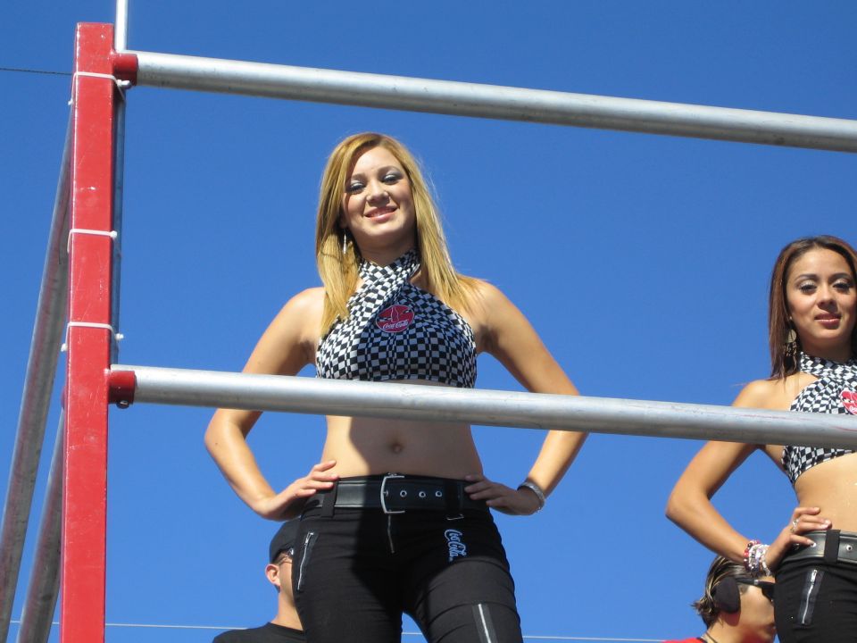 Blonde woman in checkered crop top posing on a red railed platform