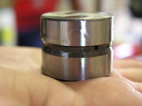 1996 Ford Probe - A close-up view of an engine lifter part, held in a person's hand.