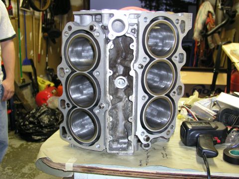 1996 Ford Probe - Engine block with six cylinder bores, likely for a V6 engine, on a workbench.