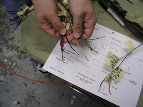 1996 Ford Probe - A person is working with a wiring harness and a diagram, likely for a vehicle repair or modification.
