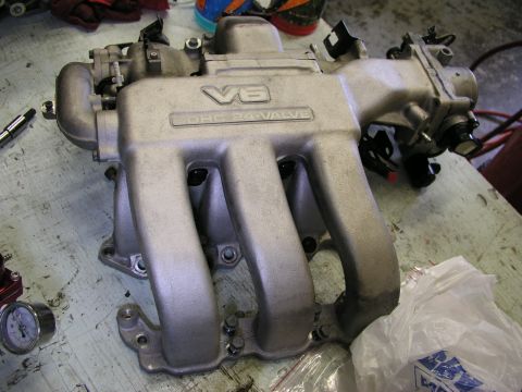 1996 Ford Probe - A V6 DOHC 24-valve intake manifold is shown on a workbench, suggesting engine work or repair.