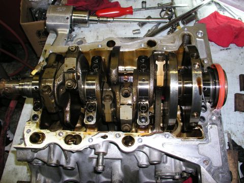 1996 Ford Probe - Engine block with crankshaft and connecting rods, tools on table during a rebuild.