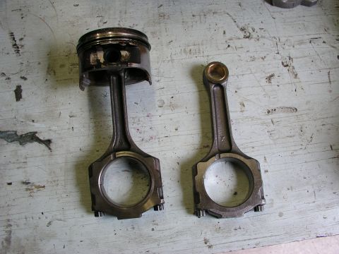 1996 Ford Probe - A used piston and connecting rod assembly are shown next to a new one, likely for a turbo motor rebuild.