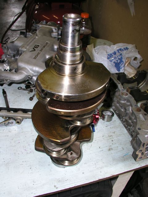 1996 Ford Probe - A V6 DOHC 24-VALVE intake manifold is visible behind a crankshaft, suggesting engine work.