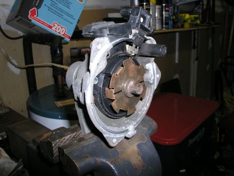 1996 Ford Probe - Close-up of a car distributor assembly, possibly for a Ford Probe, secured in a vise.
