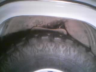 1986 Ford Bronco - A close-up view of a tire and wheel assembly, showing tread detail.
