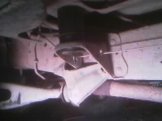 1986 Ford Bronco - Close-up view of aftermarket suspension components installed on a vehicle's frame.