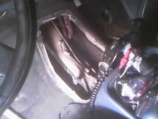 1986 Ford Bronco - This image shows the interior of a vehicle, focusing on the transmission tunnel and its exposed mechanical parts.