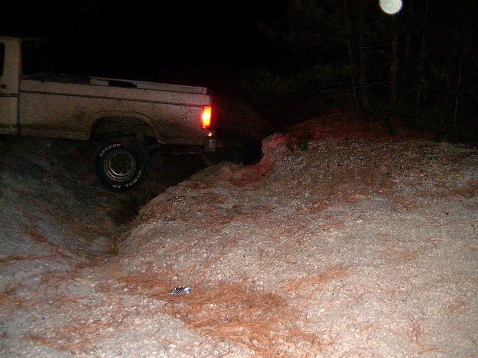 White Ford F-250 truck driving off-road at night