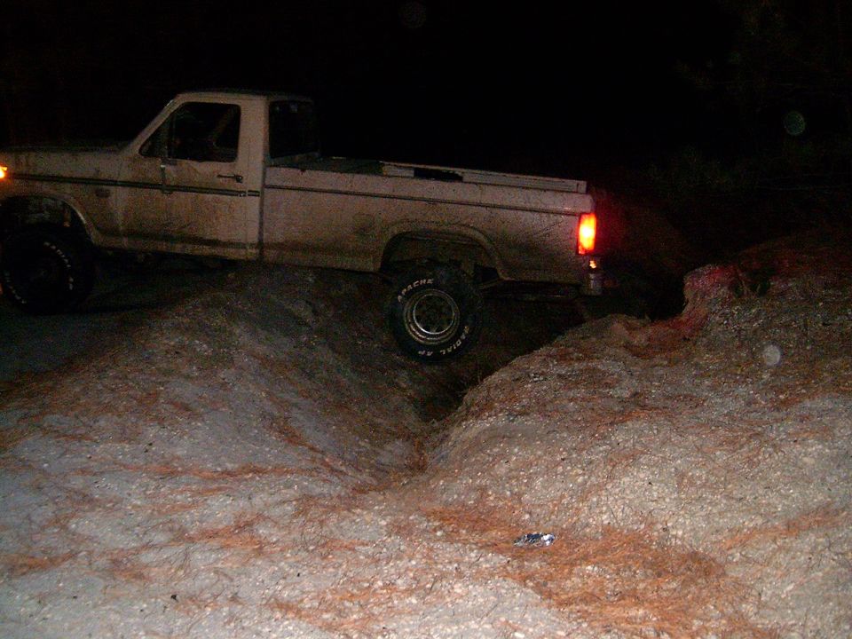 White pickup truck on an off-road trail at night. The truck appears to be from the early 1980s