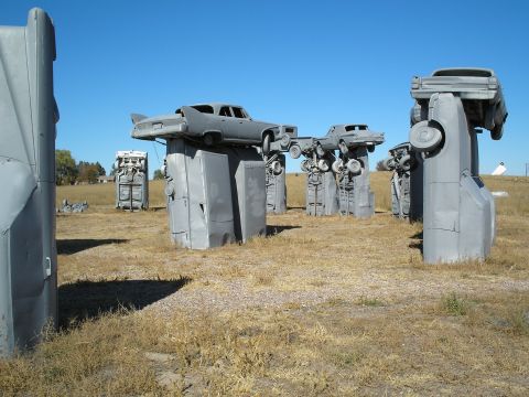 1990 Ford Bronco - An art installation features multiple cars displayed on concrete structures in an open field.