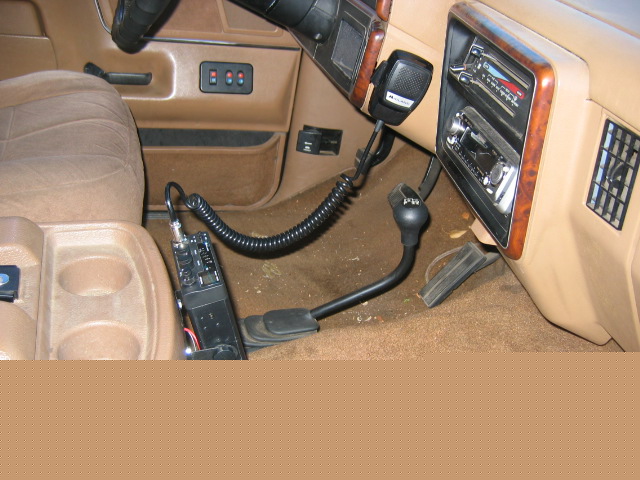 Interior shot of a vehicle's dashboard, showing a CB radio and microphone mounted near the gear shifter