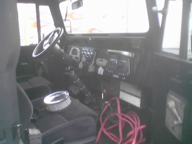 Interior of a vintage 4x4 with air cleaner on seat and wiring