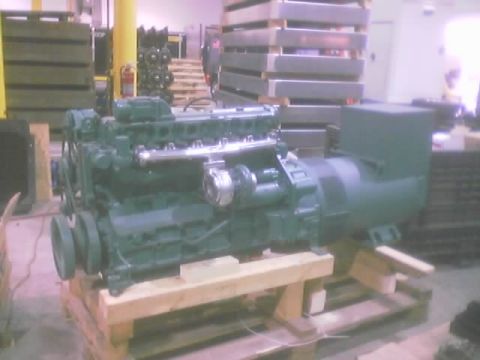 1968 Ford Mustang - A large green engine, likely for a generator, sits on wooden supports in a storage area.