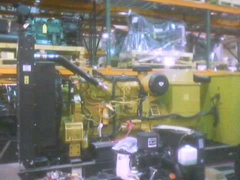 1968 Ford Mustang - A yellow generator engine is viewed from the side in a warehouse with other equipment in the background.