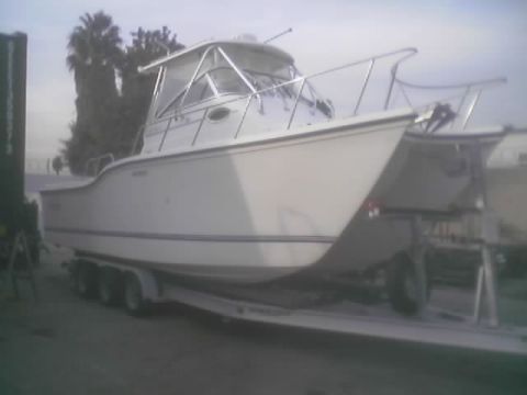 1968 Ford Mustang - A white cabin cruiser boat is parked on a trailer, ready for transport or storage.