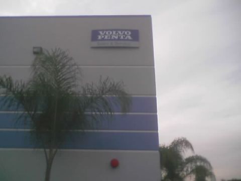 1968 Ford Mustang - Exterior view of a building with a Volvo Penta sign, partially obscured by a palm tree.