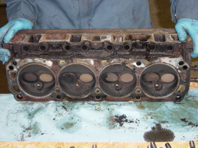 Driver's side head, w/ gasket.  Check out all the beautiful carbon buildup in the combustion chambers.