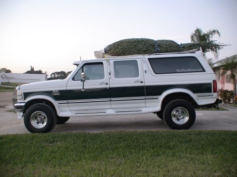 1993 Ford C-350 (Centurion Conversions) - This modified Ford van, likely a 1992 model, is seen from the side carrying a large Christmas tree.