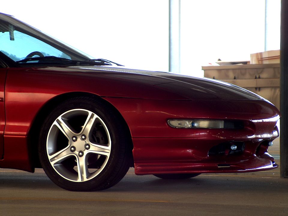 Maroon Ford Probe coupe front-left corner with alloy wheel, parked indoors